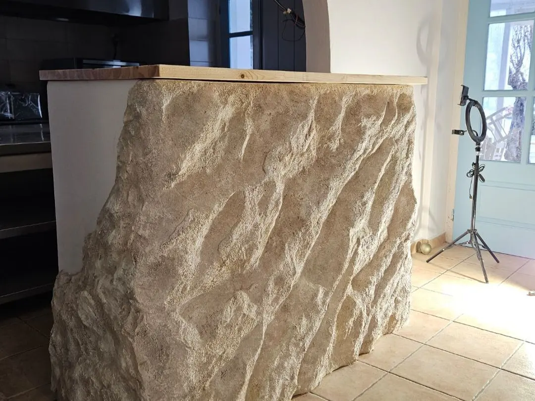 A kitchen island built as one continuous sculpted rock form