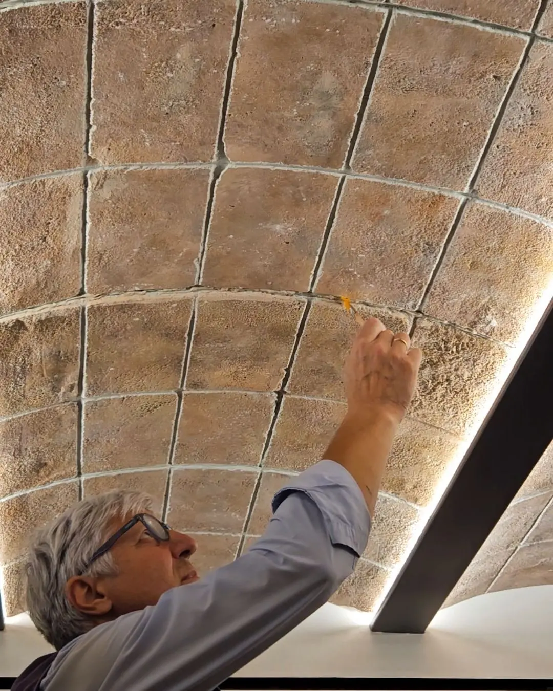 Finishing the sculpted ceiling panels by hand from a raised platform