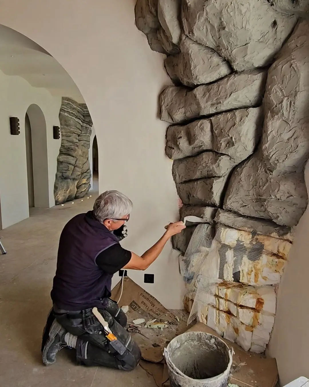 Building up an artificial rock wall beside an arched opening