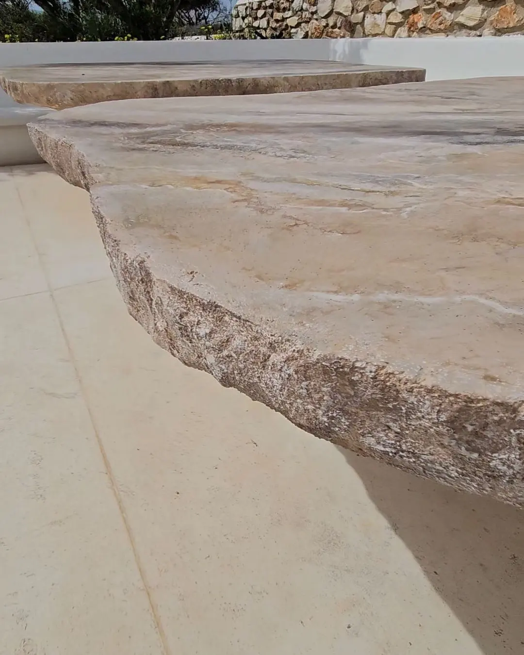 The sculpted edge of the larger stone table