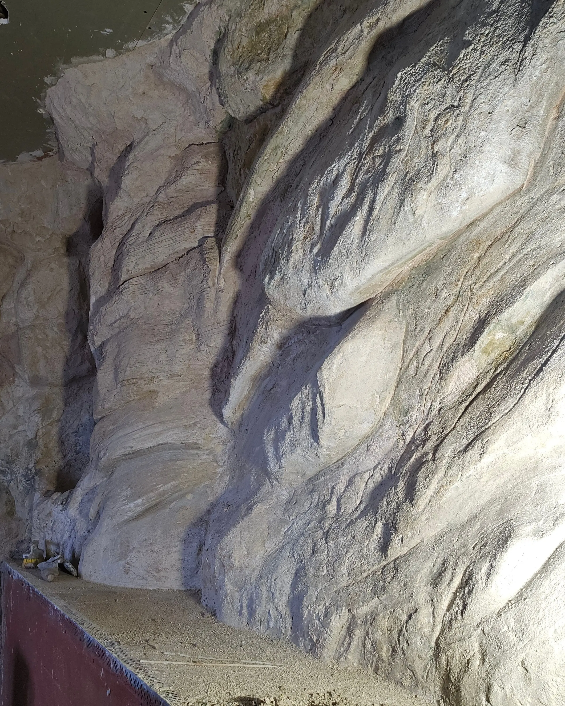 The same wall six months earlier, part-sculpted, with bare floor and primer still showing