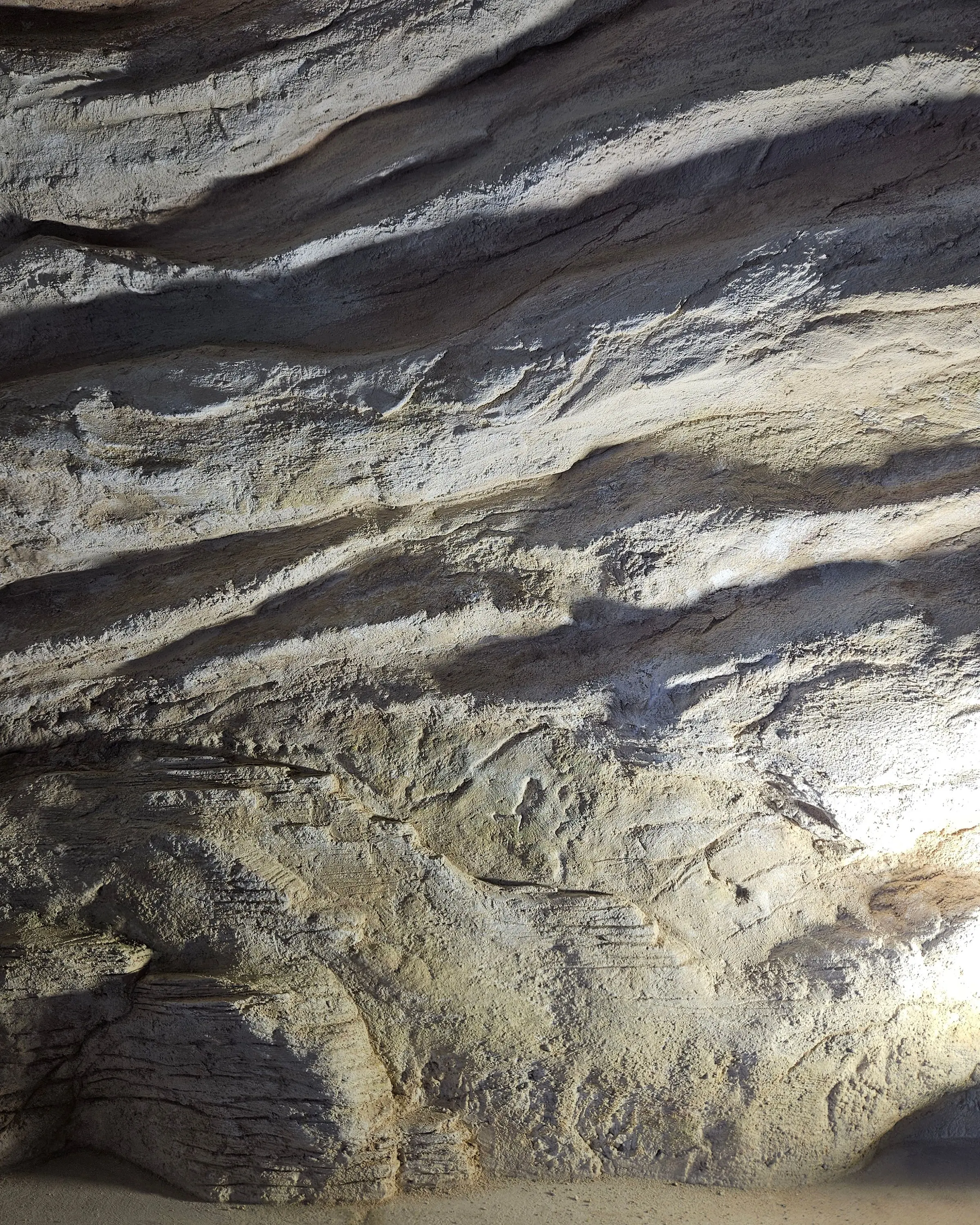 Layered bands of the rock surface being cut, before any colour is applied