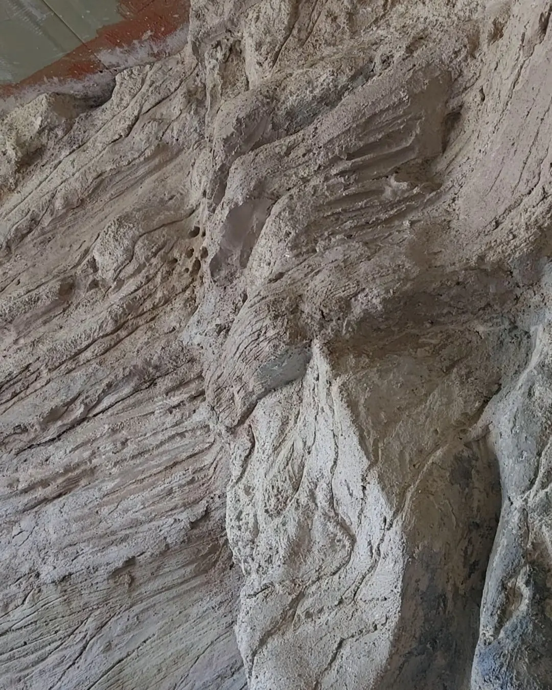 An early stage of the wall, the first layers roughed out against the bare room