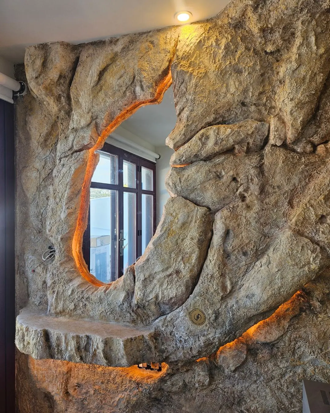 A window opening cut through the sculpted rock and edged with warm light
