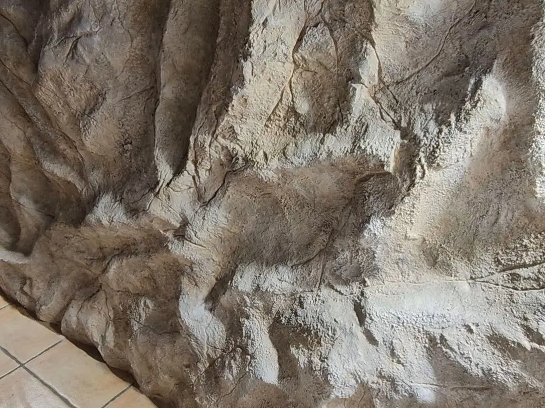 A hand-sculpted artificial rock wall running the full length of a room