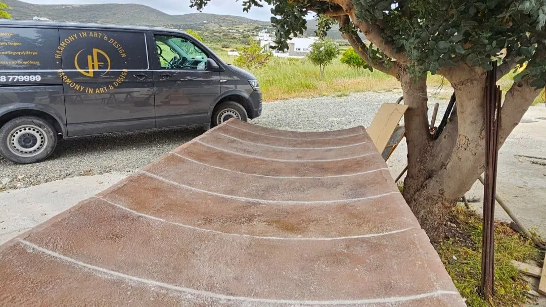 A curved stone section resting on trestles beside the studio van, part-way through fabrication
